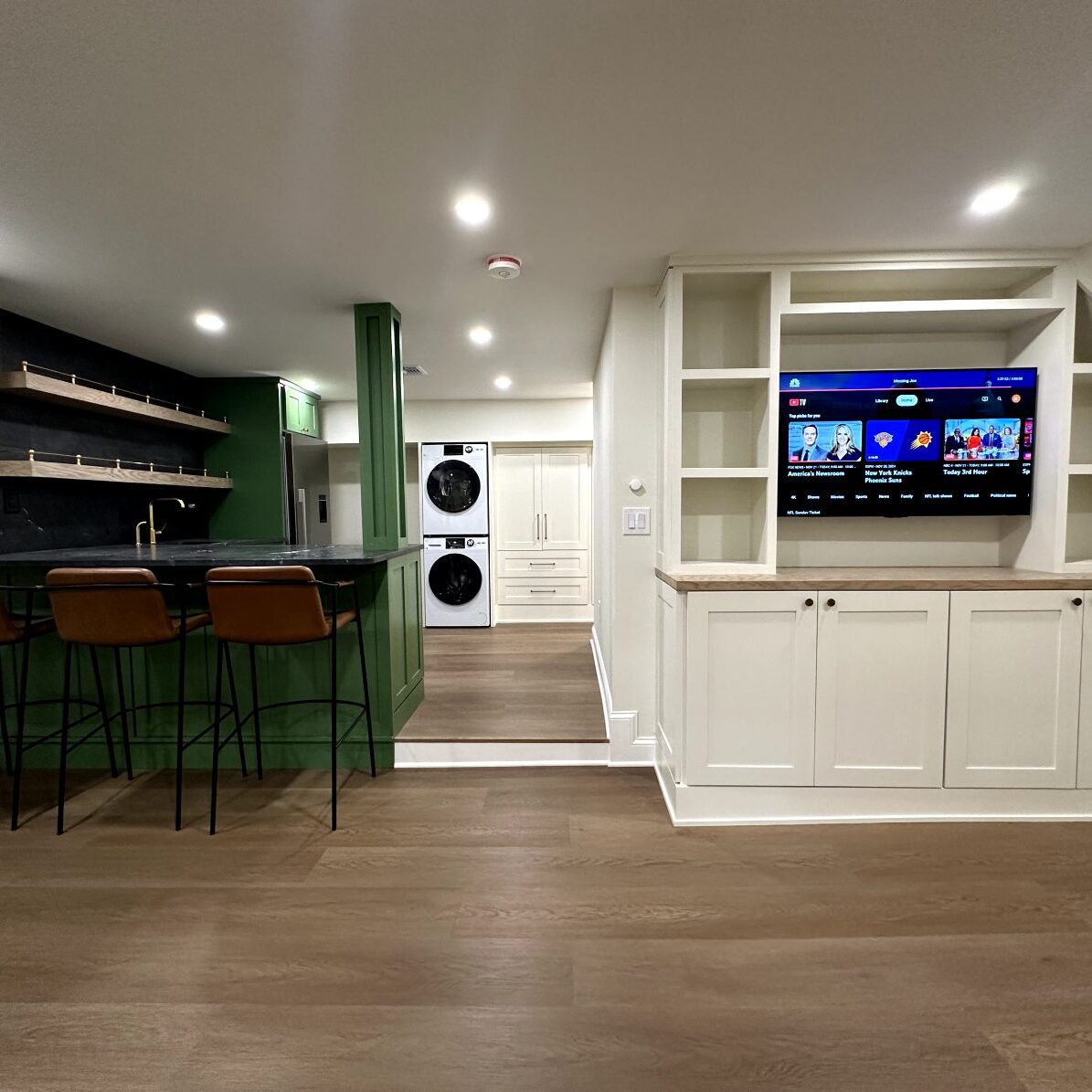 Basement bar with green island and leather stools